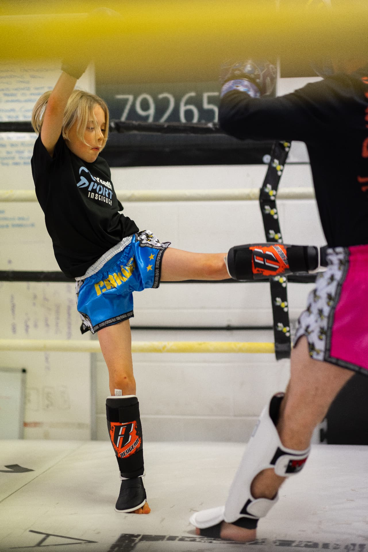 Student kicking pads during a partner drill