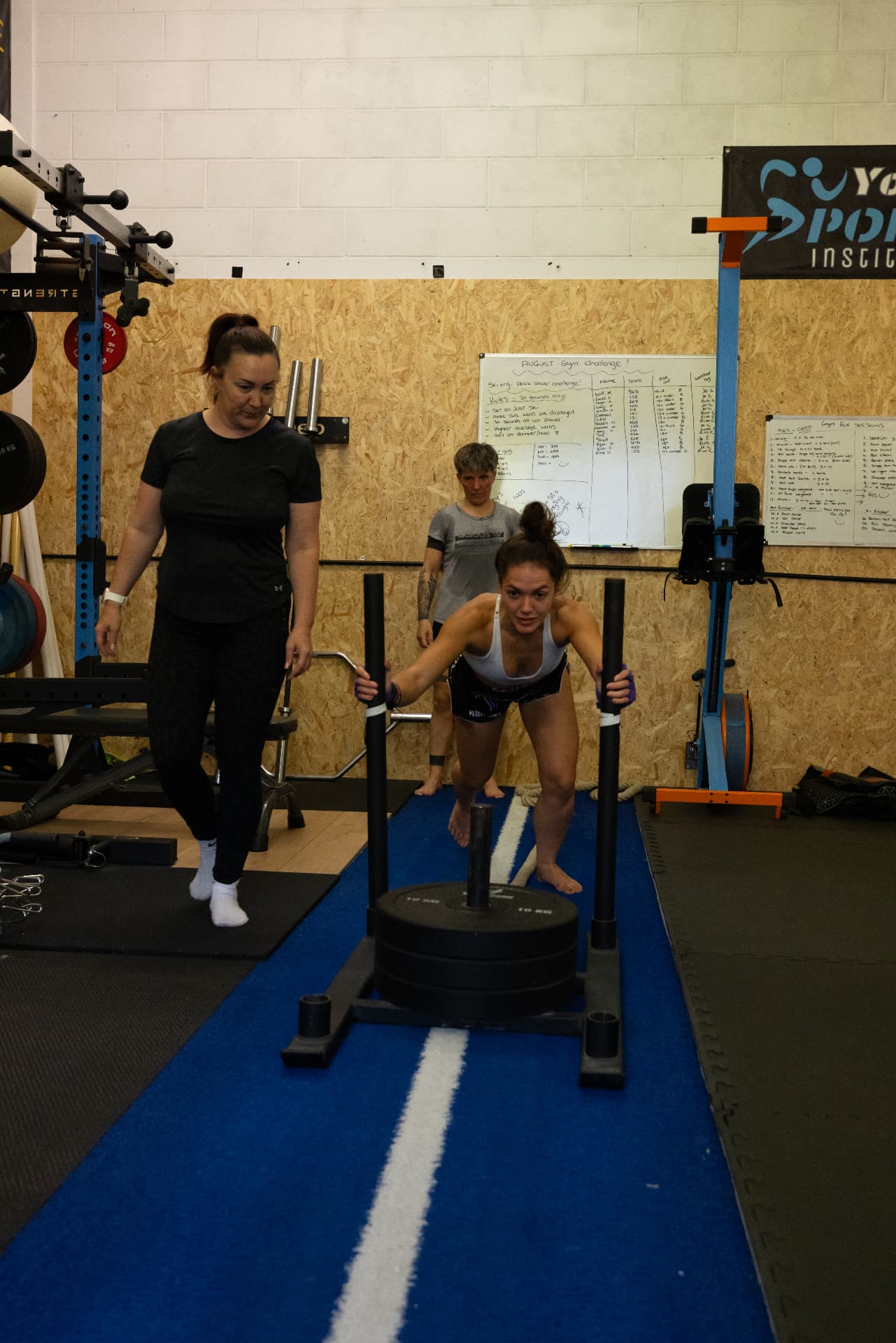Member pushing a weighted sled on the Chokdee strength and conditioning turf