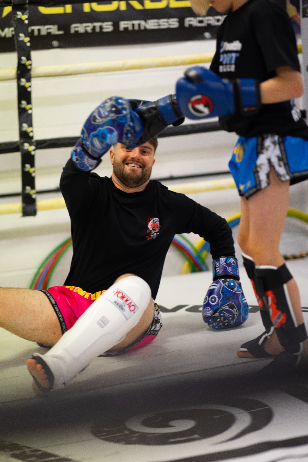 Coach and student laughing during a ring workout